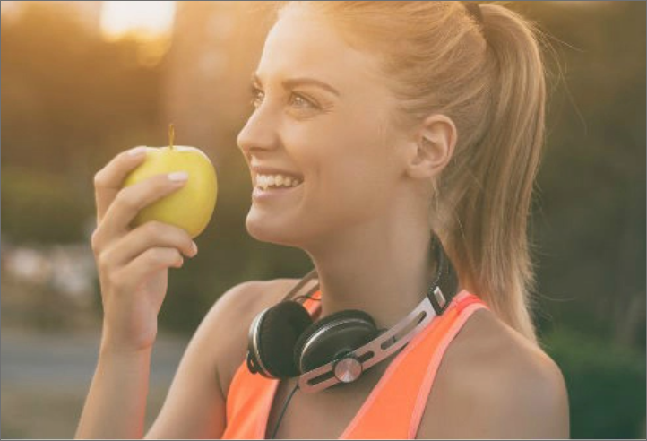 Woman holding an apple while smiling